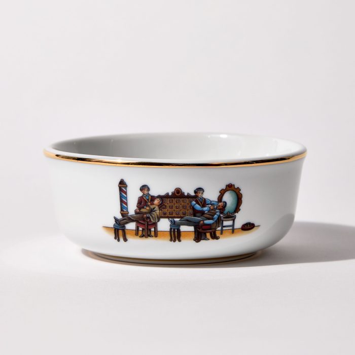 Porcelain shaving bowl with illustration of vintage barbershop scene, gold trim