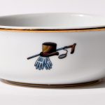 Detail view of back of shaving bowl with illustration of vintage top hat, cane, monocle