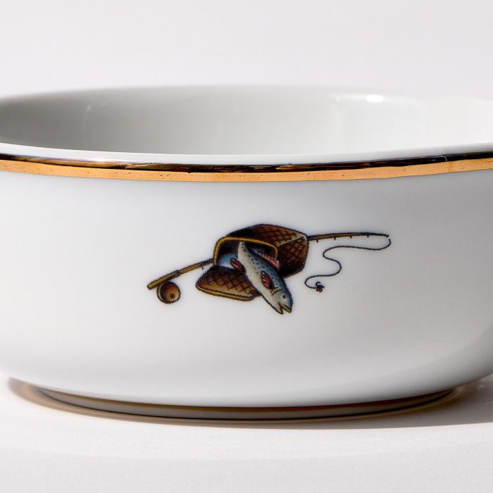 Detail view of back of shaving bowl with illustration of vintage fishing creel, fish, rod, and reel