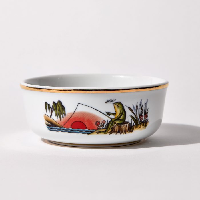 Porcelain shaving bowl with illustration of anthropomorphic frog fishing and riverside backdrop, gold trim