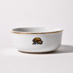 Back of shaving bowl with illustration of vintage motorcycle cap, gloves, goggles, and checkered flag