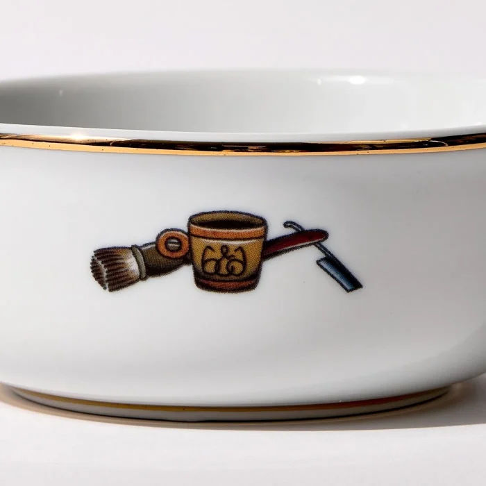 Detail view of back of shaving bowl with illustration of vintage shaving mug, brush, and straight razor