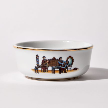 Porcelain shaving bowl with illustration of vintage barbershop scene, gold trim