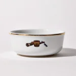 Back of shaving bowl with illustration of vintage shaving mug, brush, and straight razor