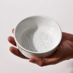 Porcelain shaving bowl with lather feature pattern, held in hand