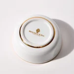 Bottom of porcelain shaving bowl showing gold Brousseau & Dov logo and gold trim around foot