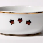 Detail view of back of shaving bowl with illustration of vintage stylized American flag stars, gold trim