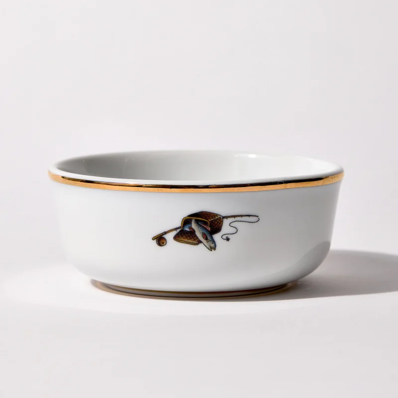 Back of shaving bowl with illustration of vintage fishing creel, fish, rod, and reel