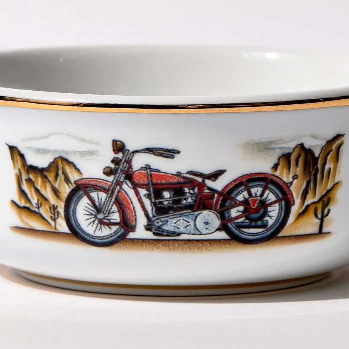 Detail view of porcelain shaving bowl with illustration of vintage Harley-Davidson motorcycle and desert backdrop, gold trim