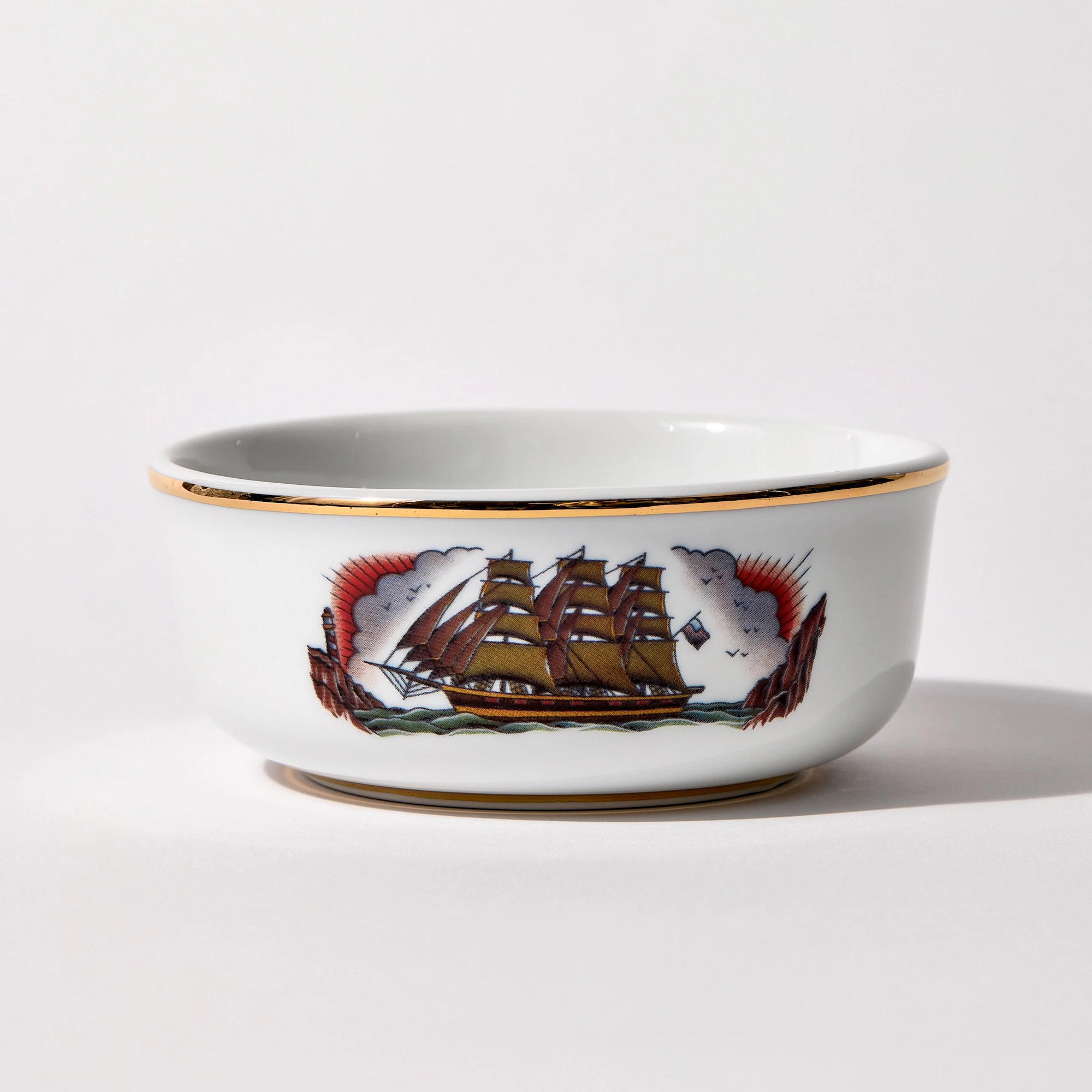 Ship_Primary_300ppi_Enhanced_WebP_2000 Porcelain shaving bowl with illustration of vintage sailing ship and port backdrop, gold trim