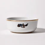 Back of shaving bowl with illustration of vintage captain's hat, sextant, and coiled rope