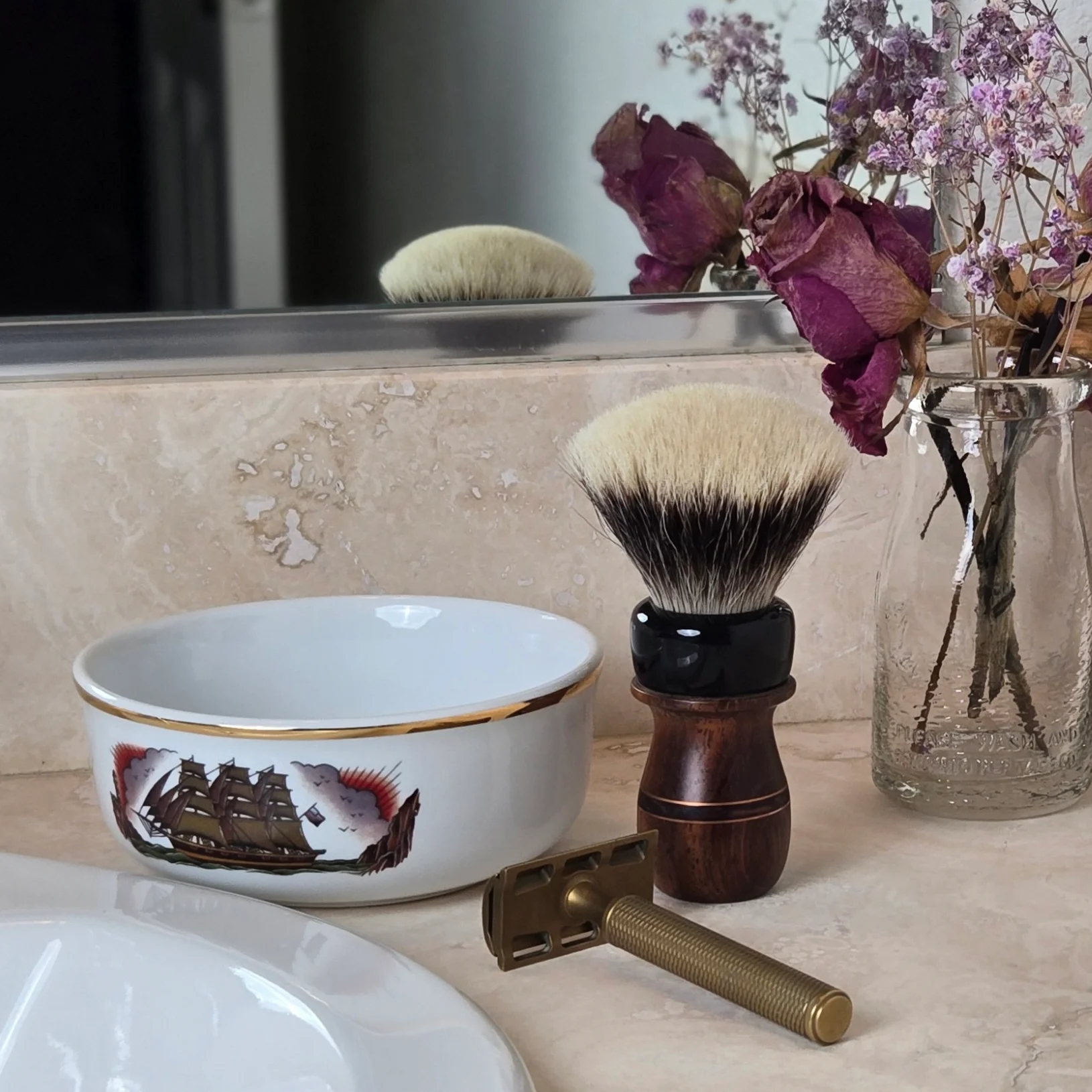 Porcelain shaving bowl, shaving brush, and safety razor on a bathroom countertop